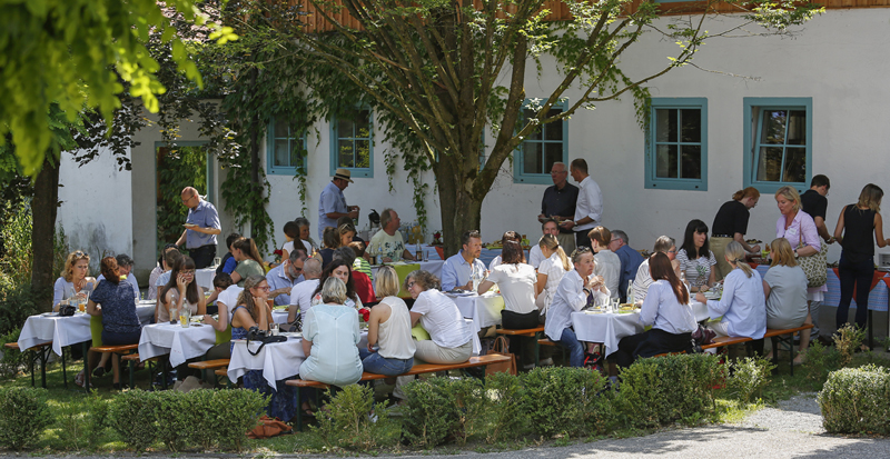 Die Gruppe der eingeladenen Journalisten und Preisträger sowie Referenten beim Mittagessen im Garten der Confido-Initiativen.